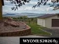 Real Estate Listing Photo. Depicting the exterior of the property with a detached structure and distant landscape features