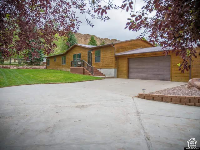 Wood-sided exterior with a metal roof, attached garage, and concrete driveway