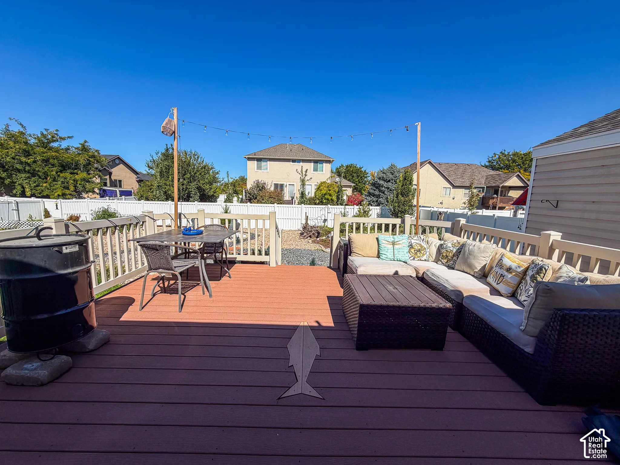 Expansive two-tone deck featuring a white railing and perimeter fencing