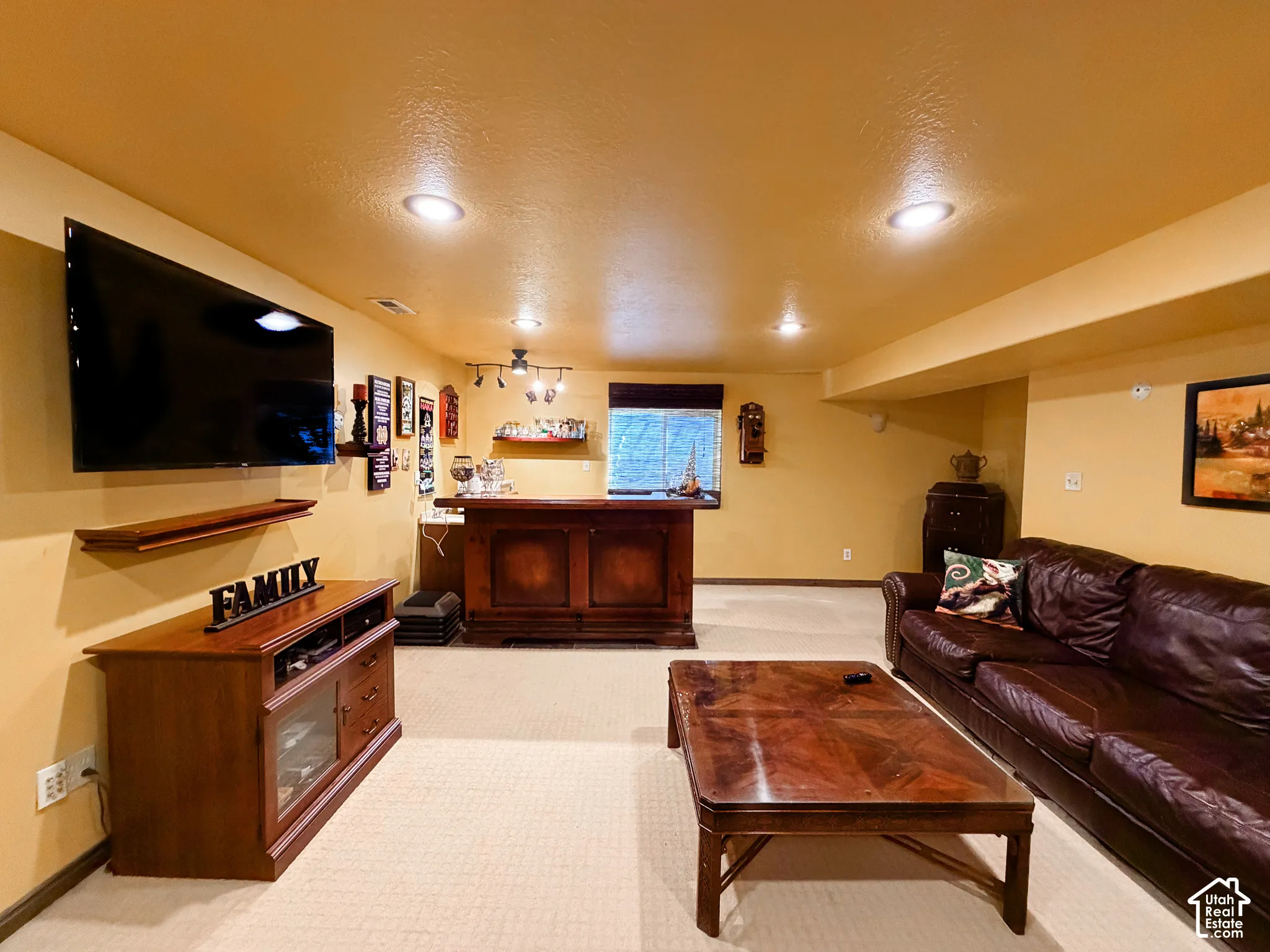 Recessed lighting illumination, built-in wet bar, and carpeted flooring