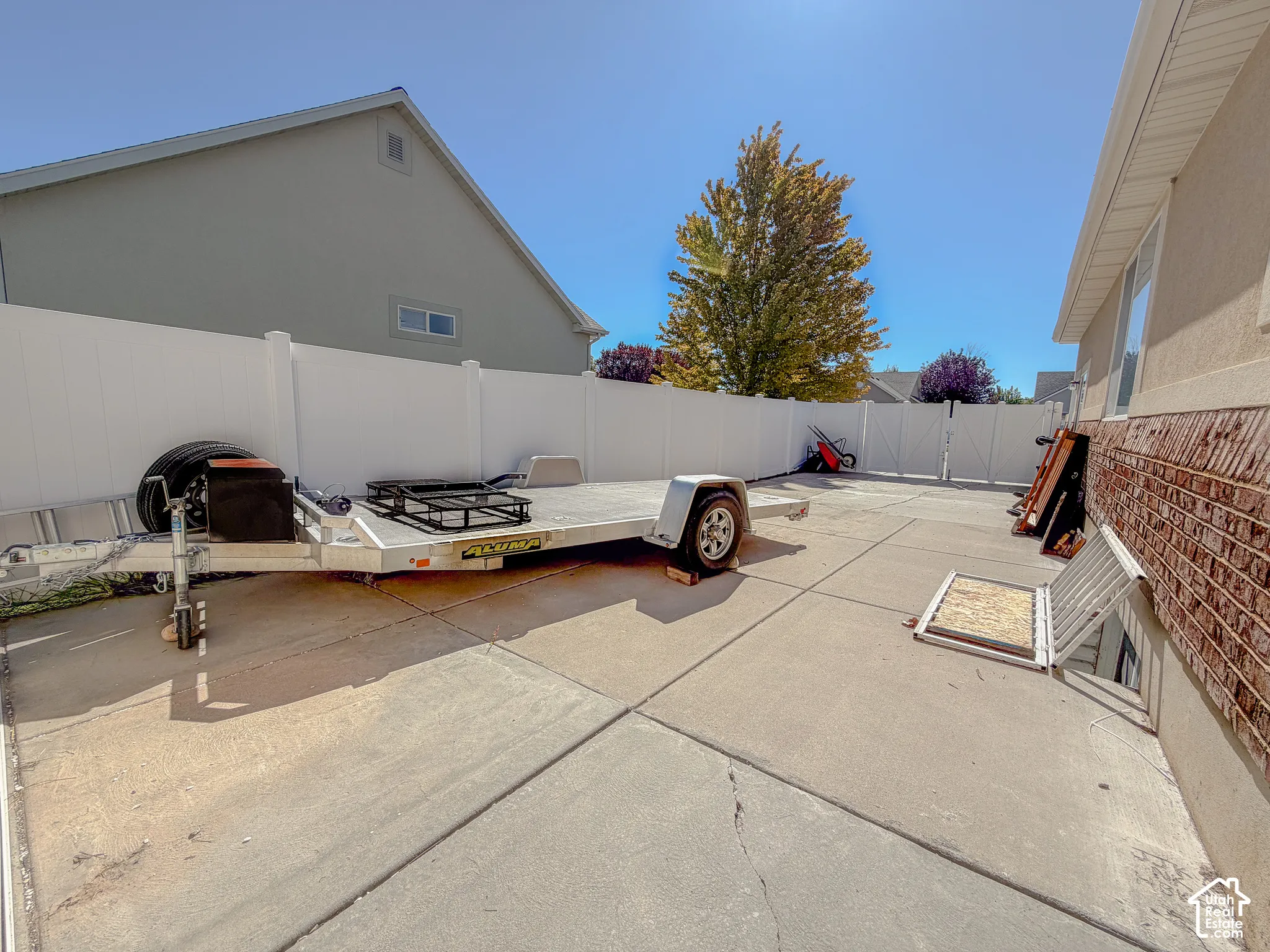 Concrete patio with perimeter fencing and brick veneer siding