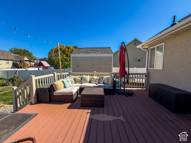 Expansive wood-finish deck with white railing, featuring a detailed fish inlay