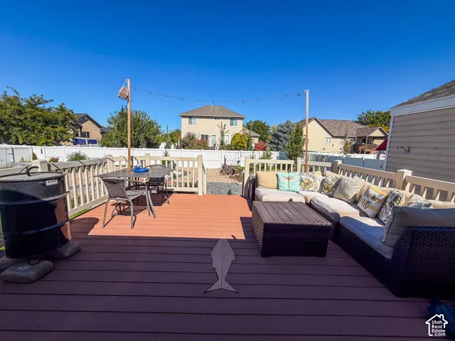 Expansive two-tone deck featuring a white railing and perimeter fencing