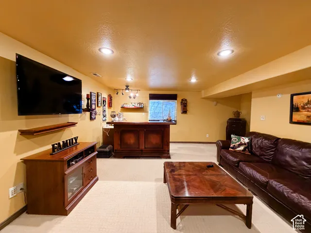 Recessed lighting illumination, built-in wet bar, and carpeted flooring