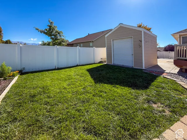White vinyl privacy fencing, manicured lawn, dedicated storage shed, and paver stone hardscaping
