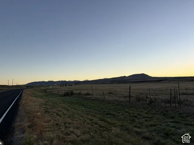 Expansive open land featuring natural grasses and distant mountains