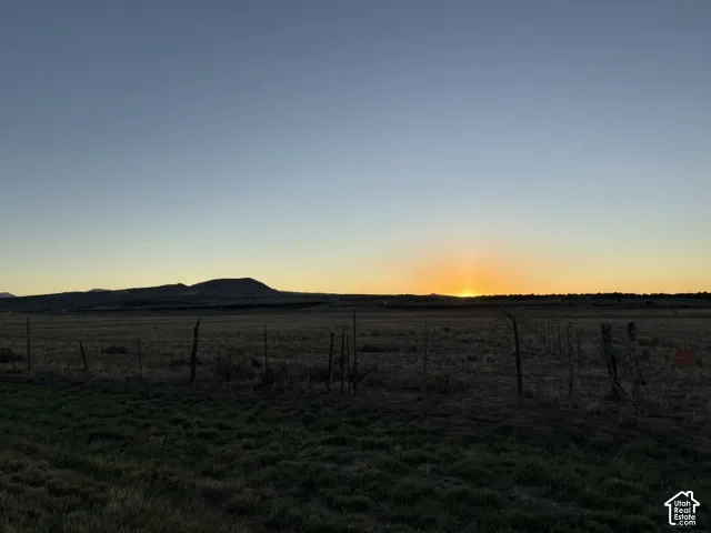 Expansive open terrain with natural vegetation, featuring distant mountain formations and a clear horizon