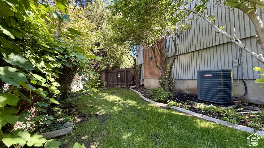 Expansive green space featuring mature trees and a privacy fence