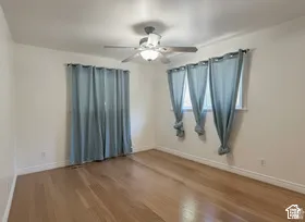 Recessed lighting, ceiling fan with light fixture, wood-finish flooring, white walls, and multiple windows