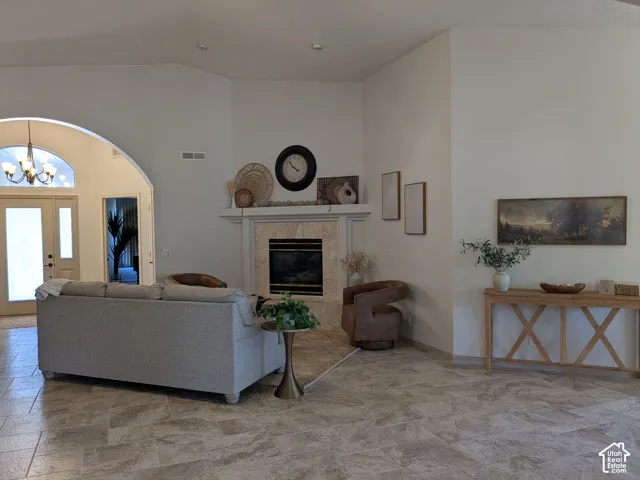 Vaulted ceilings, a fireplace with a stone surround and mantel, and large format tile flooring