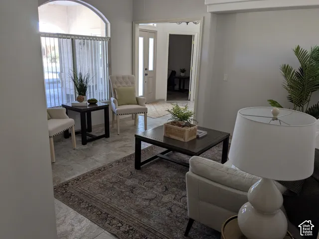 Neutral tone wall paint, arched window, tiled flooring, recessed lighting, and an open doorway