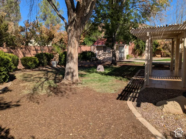 Patio featuring a slatted pergola, textured concrete flooring, and an integrated walkway