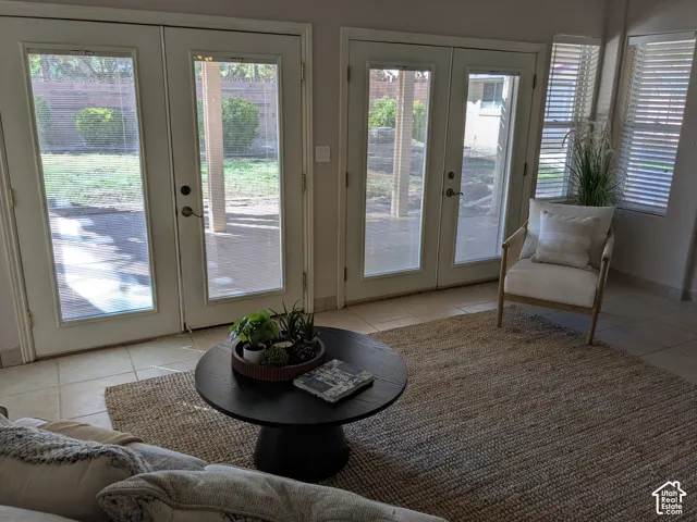Dual glass-paneled doors, tiled flooring, and multiple windows with blinds