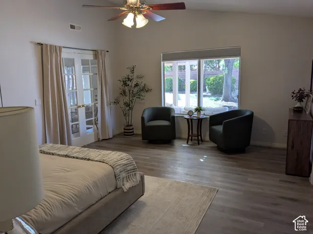 Vaulted ceilings, wood-finish flooring, ceiling fan, and French doors leading to an exterior space