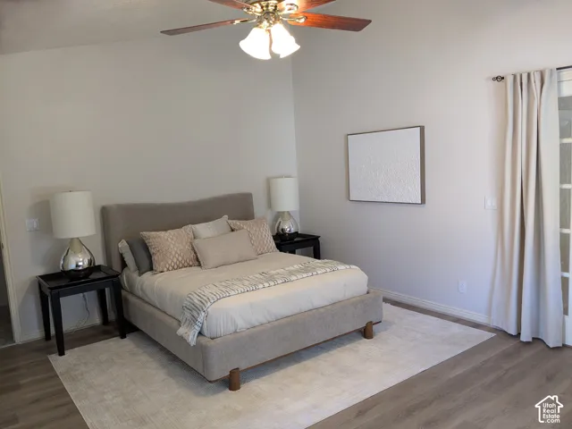 Vented ceiling fan, wood-finish flooring, and French doors with privacy curtains