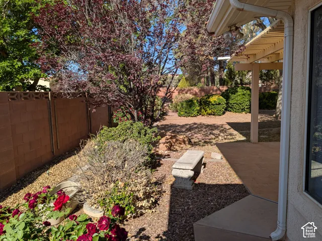 Expansive patio with an attached pergola, gravel landscaping, and mature trees