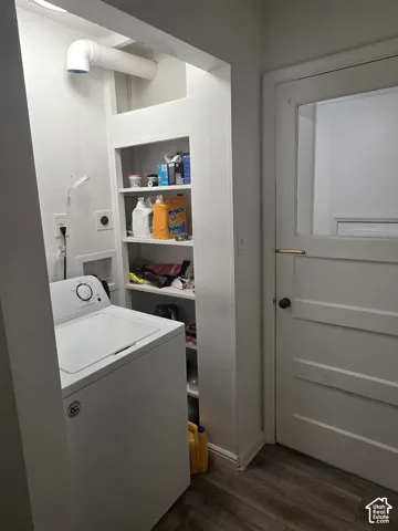 Laundry area featuring built-in shelving, a top-load washer, and wood-finish flooring