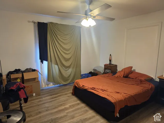 Wood-finish flooring, a ceiling fan with integrated lighting, and crown molding