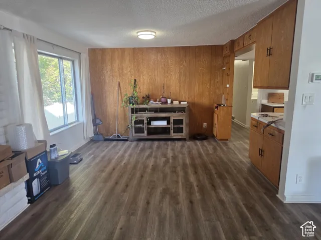 Wood-finish flooring, wood paneling, recessed lighting, and a large window