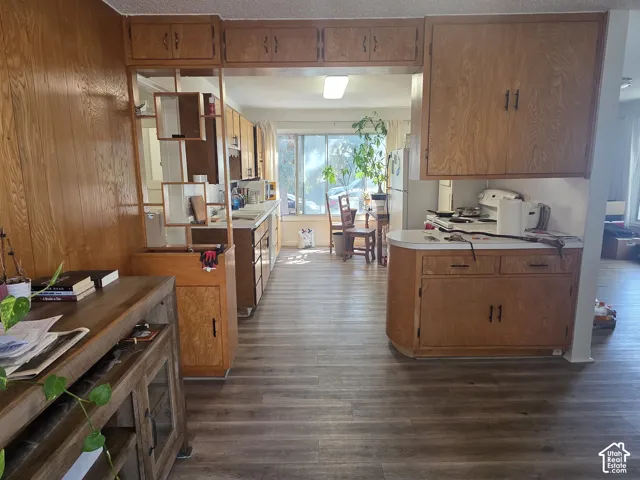 Wood-finish flooring throughout, wood paneling, wood cabinetry, and a built-in room divider