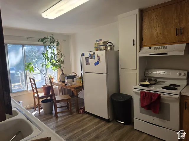 Kitchen featuring wood-finish flooring, white built-in cabinetry, and a window providing natural light