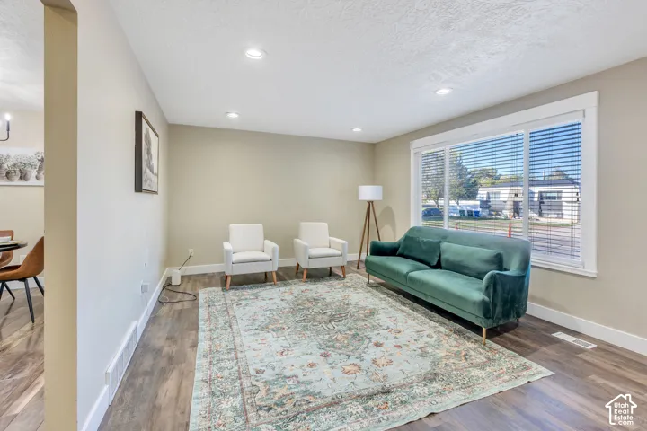 Recessed lighting, wood-finish flooring, and a large window with blinds
