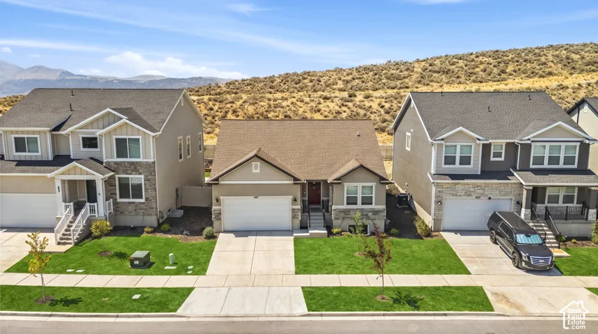 Contemporary residence with an attached two-car garage, concrete driveway, and front lawn