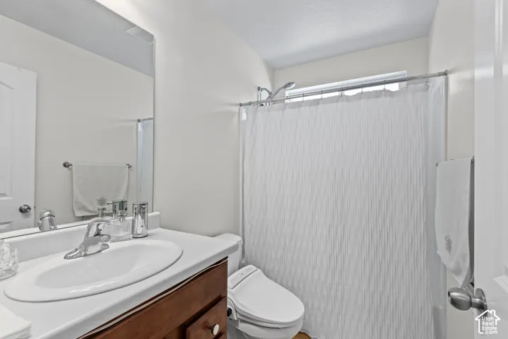 Built-in vanity with a single basin sink, chrome faucet, and wood-finish cabinetry