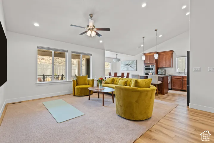 Vaulted ceilings with recessed lighting, wood-finish flooring, and multiple windows