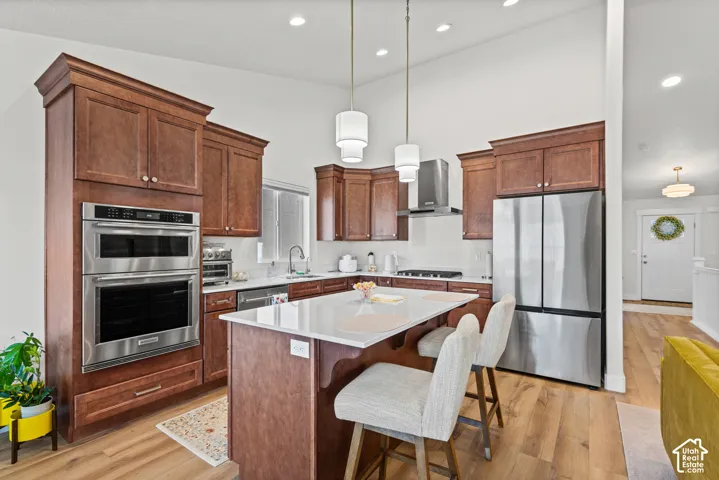 Kitchen featuring wood-finish flooring, recessed lighting, and a center island with countertop seating