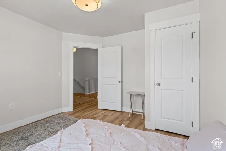 Light-colored walls with white trim, wood-finish flooring, and a flush mount ceiling light fixture