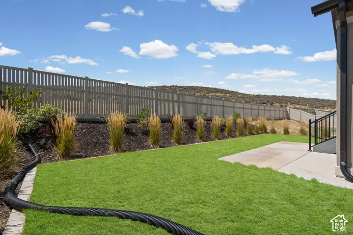 Expansive lawn area with a perimeter fence and concrete patio