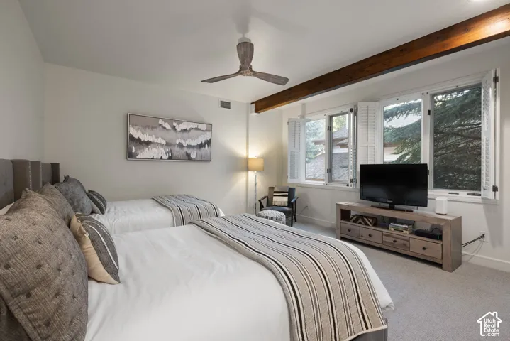 Exposed wood beam ceiling with recessed lighting, white window shutters, ceiling fan, and carpeted flooring