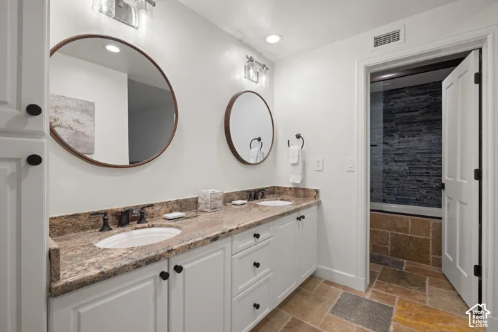 Dual vanity with granite countertop, integrated sinks, and bronze-finish fixtures