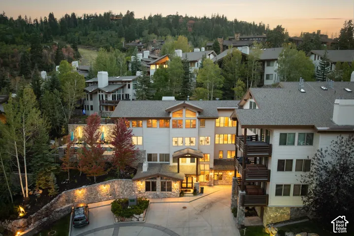 Multi-level property with stone and siding exterior, multiple balconies, and abundant windows
