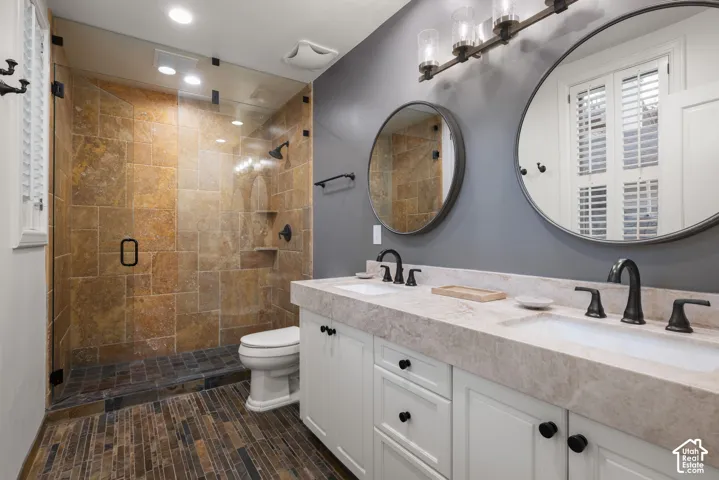 Double vanity with white cabinetry, light-toned countertop, and matte black hardware