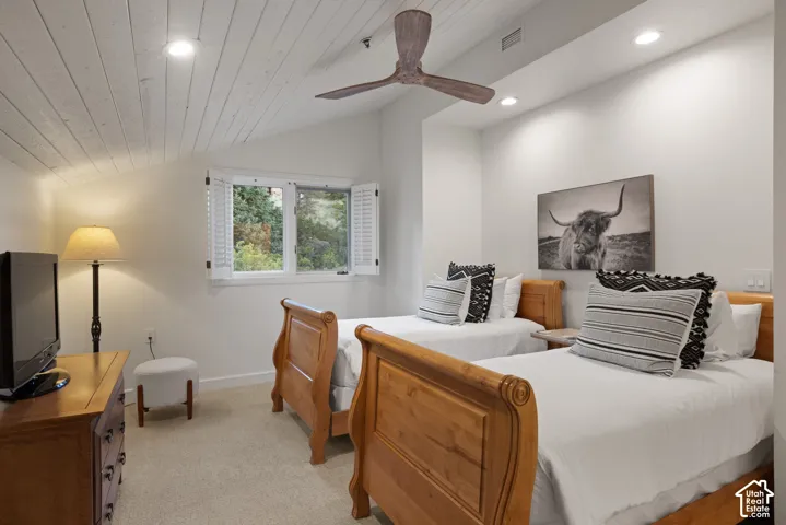 Vaulted wood-paneled ceiling with recessed lighting and a ceiling fan