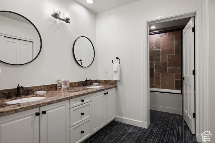 Dual vanity with stone-finish countertop, undermount sinks, and dark-finish hardware
