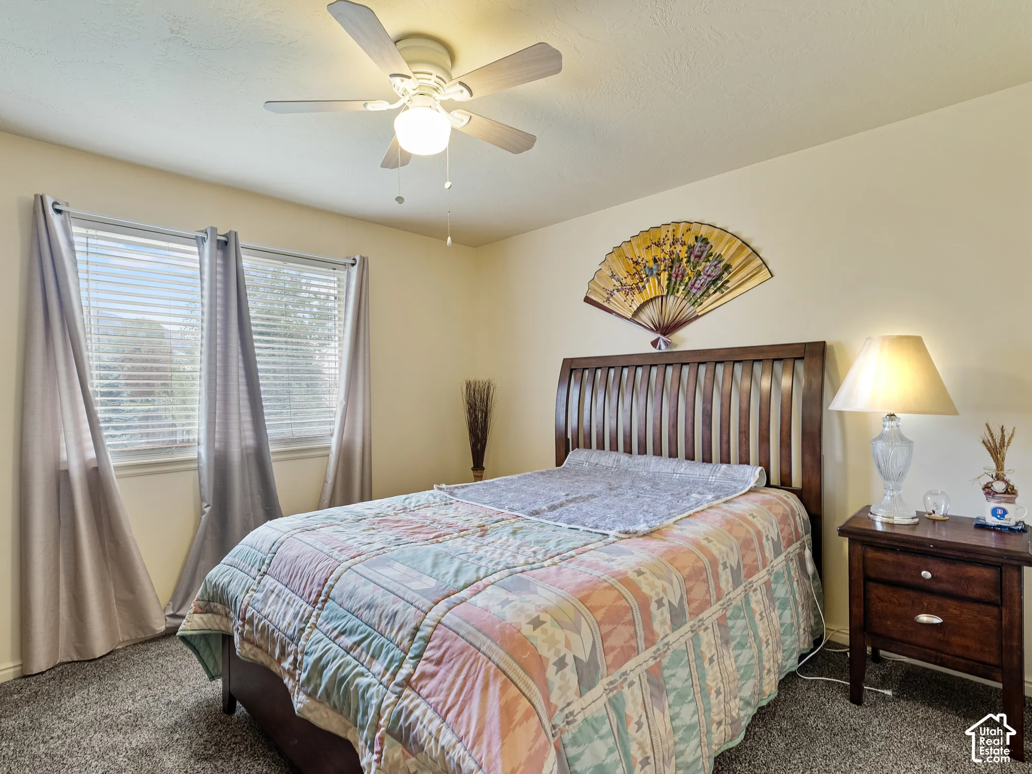 Recessed windows with blinds, ceiling fan, and carpeted flooring