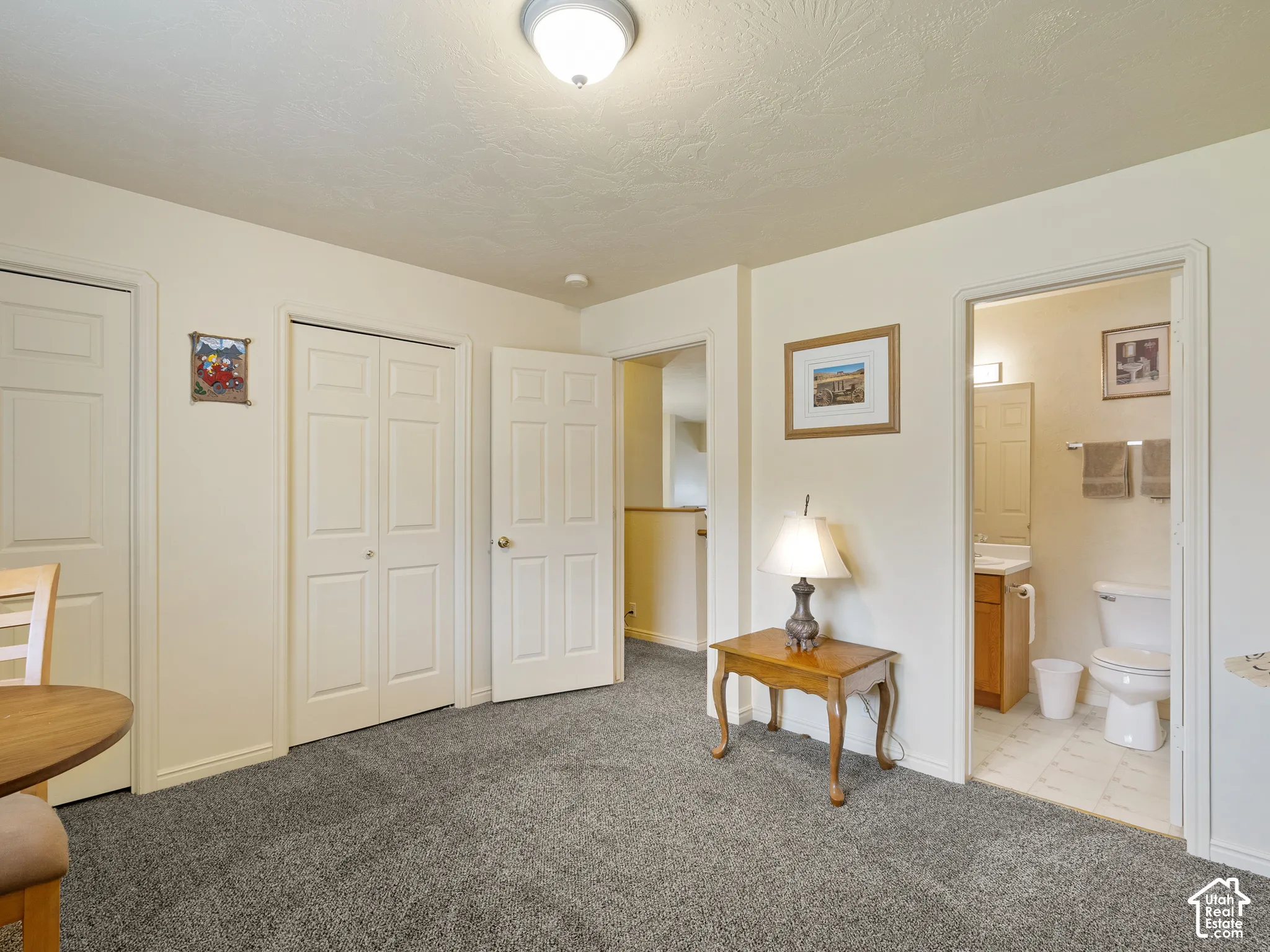 Gray textured carpeting, multiple panel doors, and a bathroom with tile flooring