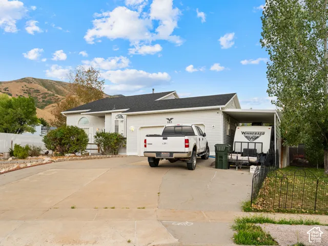 White siding exterior with an attached garage, covered carport, and a concrete driveway