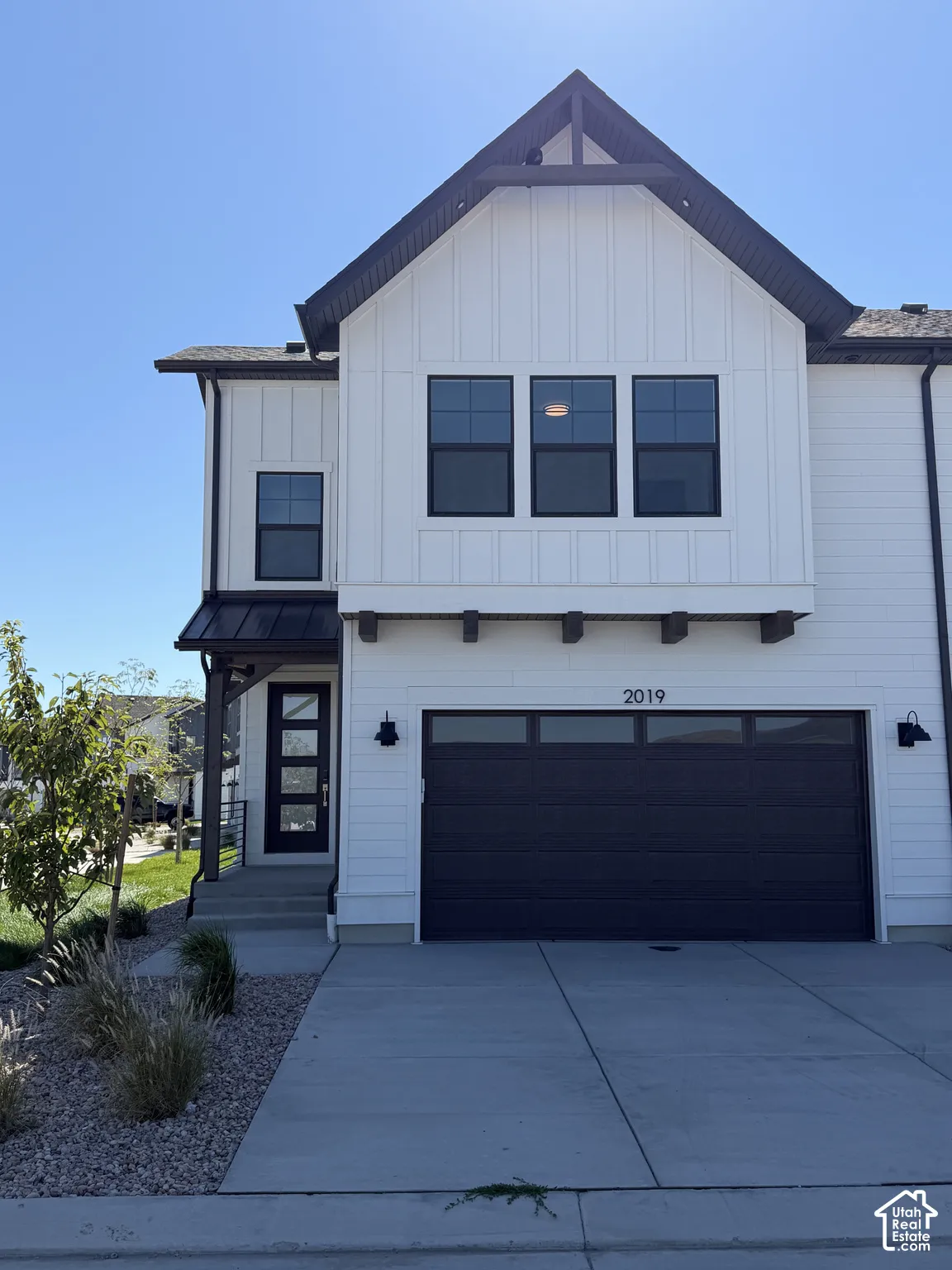 Contemporary exterior with white vertical siding and dark trim