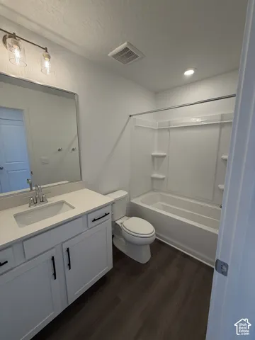 White vanity with dark hardware, undermount sink, and light countertop