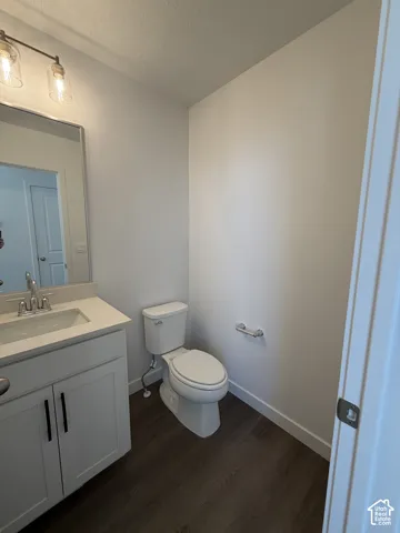 White vanity with a single sink, light-toned countertop, and dark cabinet hardware
