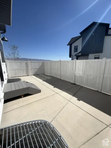 Private concrete patio area featuring light-toned privacy fencing