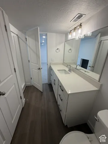 Dual sink vanity with white cabinetry and dark hardware