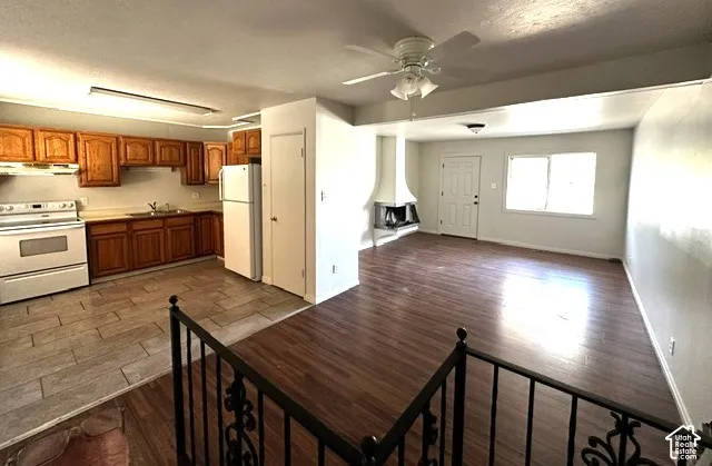 Kitchen with wood cabinetry, white appliances, and tiled flooring