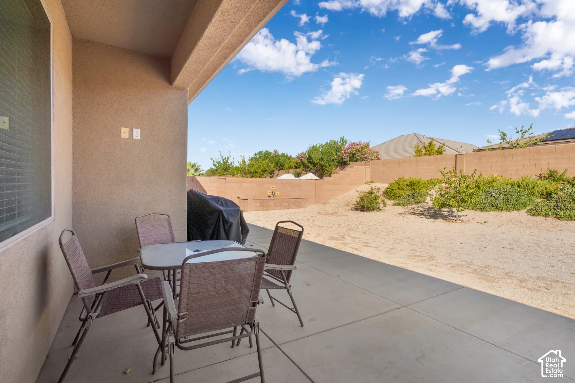 Partial Covered patio with a concrete surface, stucco exterior, and a privacy wall