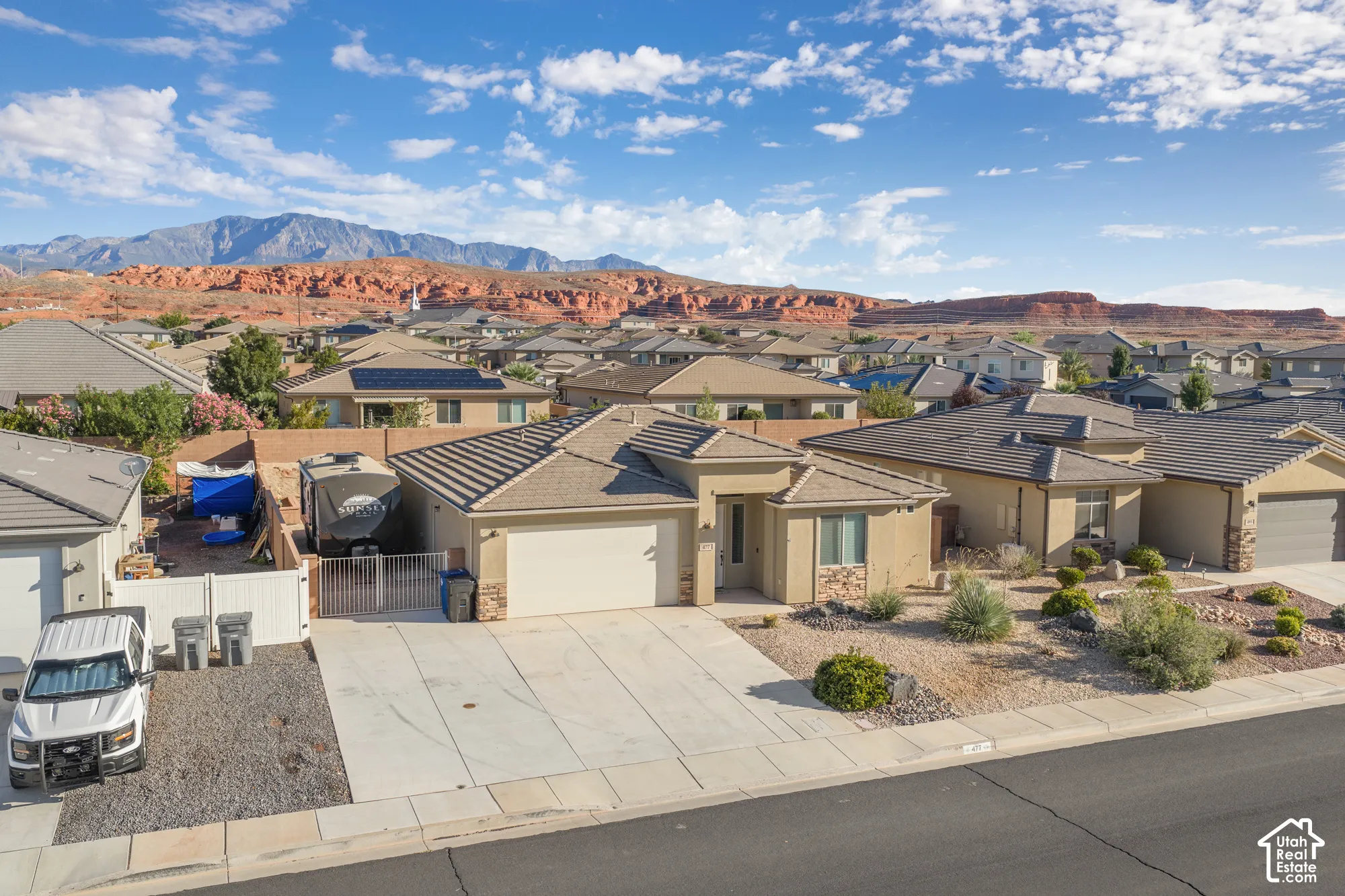 Single-story residential property with a concrete driveway, attached two-car garage, and a low-maintenance front yard featuring desert landscaping