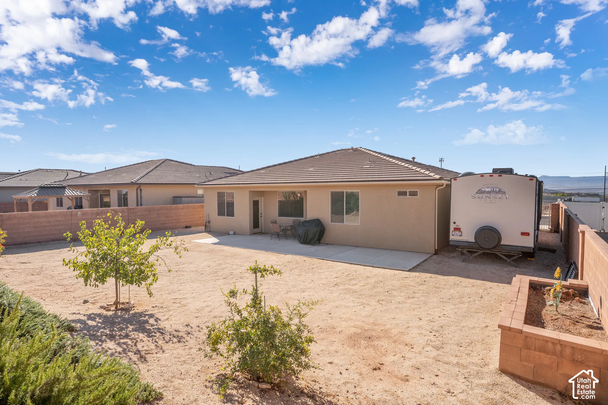 Expansive backyard with a concrete patio, a raised garden bed and side RV parking